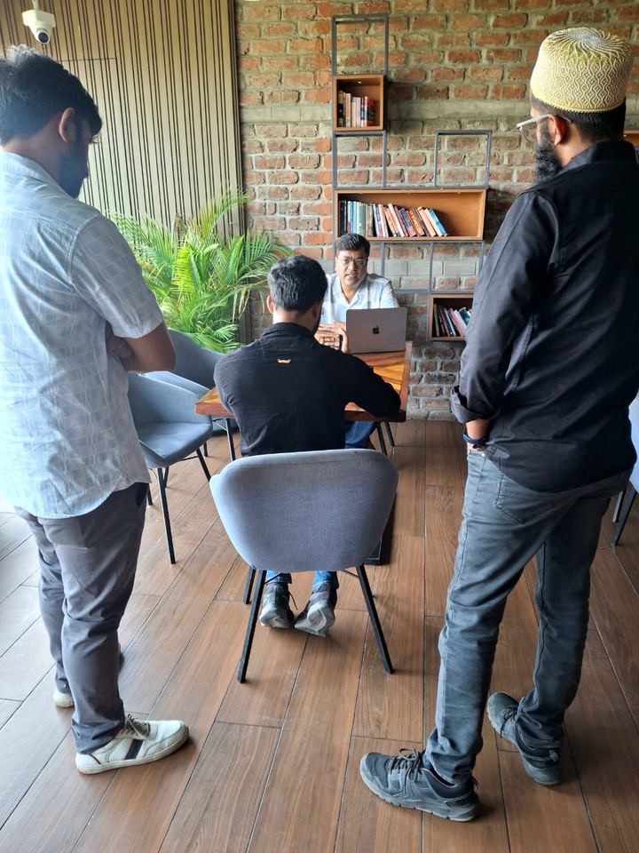A working session in a co-working space, with a laptop and a standing discussion