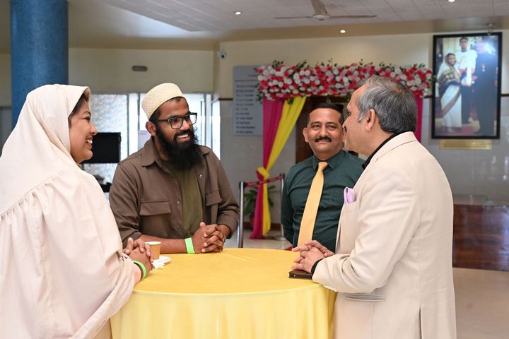 Two colleagues in conversation with two guests at a table during an event