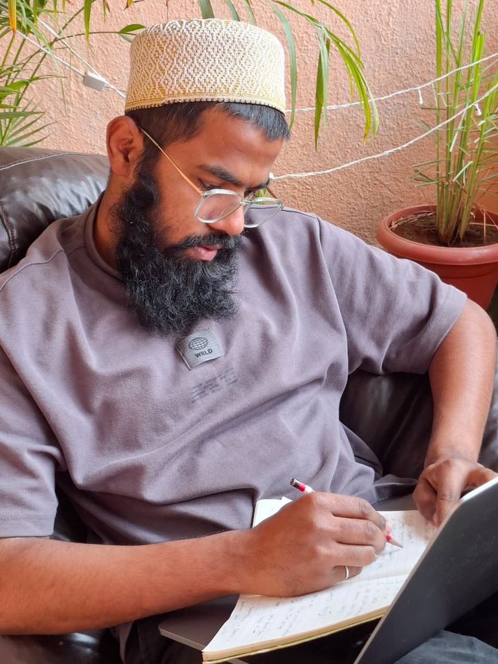 Writing ideas in a notebook while seated in a lounge chair