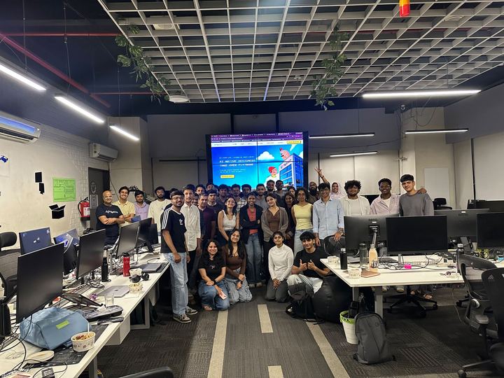 A full-room group photo of attendees after a session in a large open-plan office